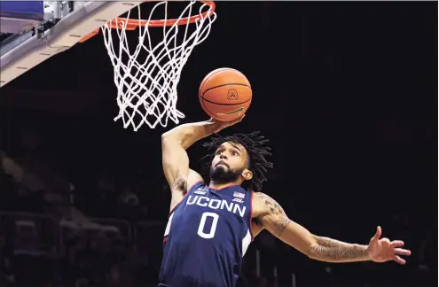  ?? Brady Klain / Getty Images ?? UConn’s Jalen Gaffney goes up for a dunk against Butler in Indianapol­is on Thursday. UConn won 75-56.