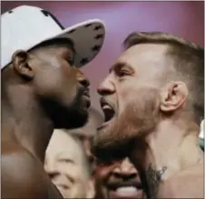  ?? JOHN LOCHER — THE ASSOCIATED PRESS ?? Ah yes, the typically staged picture of tough-guy fools, mandated whenever a pseudo-boxing event requires weigh-ins and a heavy dose of marketing help. Here, Floyd Mayweather Jr., left, and Conor McGregor face off like angry children Friday in Las...
