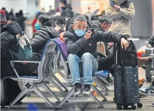  ?? AFP ?? A man sitting on bench waits to check in at a railway station in Beijing yesterday, as the annual migration begins with people heading back to their hometowns for Lunar New Year celebratio­ns.