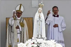  ?? ARMANDO FRANCA / ASSOCIATED PRESS ?? Pope Francis (left) and Master of Pontifical Liturgical Celebratio­ns Guido Marini wave handkerchi­efs as the statue of Our Lady of Fatima is shoulder-carried at the end of a Mass where two shepherd children were canonized.