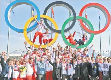  ??  ?? This file photo shows Russia’s President Vladimir Putin (centre) posing for a photo with Russian athletes, winners of the Sochi 2014 Winter Olympics, in Sochi. — AFP photo