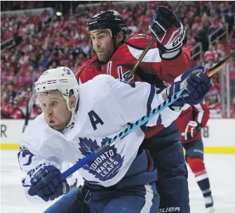  ??  ?? Maple Leafs centre Leo Komarov and Capitals left wing Daniel Winnik watch the puck during the first period in Game 2 of their playoff series in Washington on Saturday.
