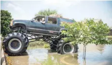  ?? — AFP ?? Old Habits, the monster truck, helps rescue residents through floods in Port Arthur, Texas.