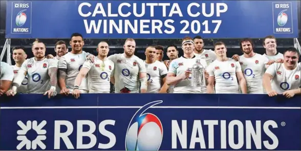  ?? BEN STANSALL/AFP ?? England’s hooker and captain Dylan Hartley holds the Calcutta Cup trophy as he poses with teammates atfter winning the Six Nations internatio­nal rugby union match between England and Scotland at Twickenham stadium in southwest London on Saturday.