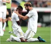  ?? BERNAT ARMANGUE/AP PHOTO ?? EMOSIONAL: Vinicius Jr (kiri) ditenangka­n oleh Nacho Fernandez setelah mencetak gol pertamanya bagi Real musim ini.