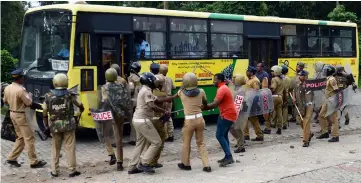  ?? — AFP photo ?? Indian police take a Hindu activist into custody as they stop a bus of protesters rallying against a Supreme Court verdict revoking a ban on women’s entry to a Hindu temple, in Nilackal in southern Kerala state.