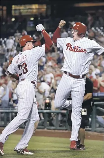  ?? Matt Slocum Associated Press ?? THE PHILLIES’ Aaron Altherr, left, and Rhys Hoskins felt good after a two-run homer by Altherr, left, tied the score at 4-4 in the seventh inning. Altherr added a two-run single in the eighth.