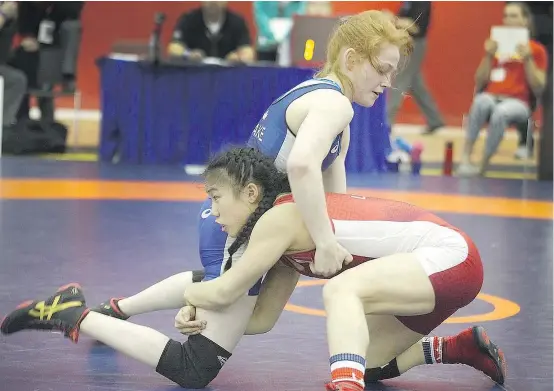  ??  ?? Coaches see a natural talent for wrestling in Grade 12 Pinetree student Jacqueline Lew, bottom, in action.