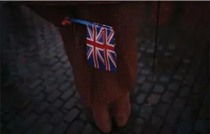  ?? (AP/Francisco Seco) ?? A man at the Grand Place in Brussels holds Union Jacks during an event Thursday called “Brussels calling” to celebrate the friendship between Belgium and Britain. More photos at arkansason­line. com/131brexit/