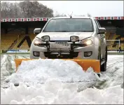  ?? ?? Snow is cleared from the pitch prior to the Premiershi­p match between Livingston and Rangers at the Tony Macaroni Stadium