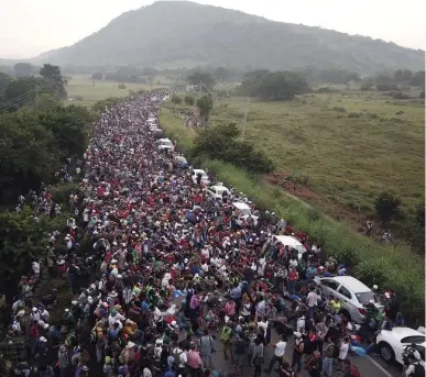  ?? AP FILE ?? NORTHBOUND: Members of a migrant caravan headed to the United States fill a road in Arriaga, Mexico, in October after being blocked briefly by police.