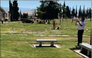  ?? RECORDER PHOTOS BY CHARLES WHISNAND ?? Mike Smith with Tom Bear in the background perform Echo Taps to conclude Monday’s observance at Hillcrest Cemetery.