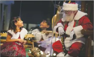  ?? (AP/Seth Wenig) ?? Gracelynn Blumenfeld, 8, visits with Santa through a transparen­t barrier at a Bass Pro Shop in Bridgeport, Conn.