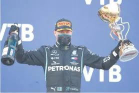  ?? - AFP photo ?? Bottas celebrates on the podium after winning the Formula One Russian Grand Prix at the Sochi Autodrom Circuit in Sochi.