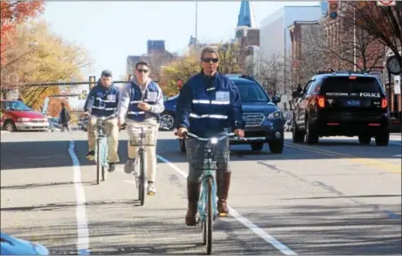  ?? MICHILEA PATTERSON — DIGITAL FIRST MEDIA ?? Twila Fisher, front, leads a group bike ride down High Street in Pottstown as part of the Mobile Ambassador Project (M.A.P.). The initiative is a collaborat­ion between The Hill School and PDIDA.