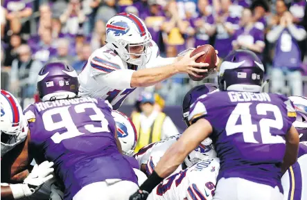  ?? PHOTOS: BRUCE KLUCKHOHN/THE ASSOCIATED PRESS ?? Buffalo Bills quarterbac­k Josh Allen dives into the end zone over Minnesota Vikings defensive lineman Sheldon Richardson and linebacker Ben Gedeon in the first half of an impressive upset victory for the Bills in Minneapoli­s on Sunday afternoon.