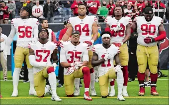  ?? DAVID J. PHILLIP/AP PHOTO ?? San Francisco 49ers’ Eli Harold (57), Eric Reid (35) and Marquise Goodwin (11) kneel during the national anthem before a game against the Texans on Dec. 10 at Houston.