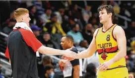  ?? CURTIS COMPTON/CURTIS.COMPTON@AJC.COM ?? Hawks forwards Kevin Huerter (left) and Danilo Gallinari slap hands during a 129-121 win over the Lakers on Sunday at State Farm Arena.