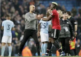  ?? THE ASSOCIATED PRESS ?? Manchester United’s Paul Pogba shakes hands with Manchester City coach Pep Guardiola at the end of the English Premier League soccer match between Manchester City and Manchester United at the Etihad Stadium in Manchester, England, Saturday.