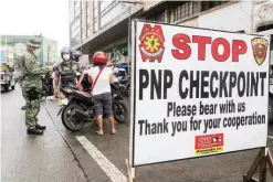  ?? (Jansen Romero) ?? MANILA police set up a checkpoint at Divisoria in Binondo to strictly enforce the health protocols against the spread of COVID-19 during the Yuletide season.