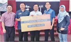  ??  ?? Azizul (centre) receiving the RM200,000 social innovation grant from Yayasan Inovasi Malaysia.