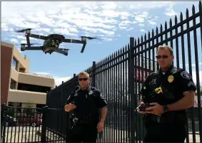  ?? Arkansas Democrat-Gazette/STATON BREIDENTHA­L ?? North Little Rock Police officer Andrew Miles (right) flies a drone Friday along with Sherwood Police Sgt. Keith Wilson as they demonstrat­e the technology used by the department­s.