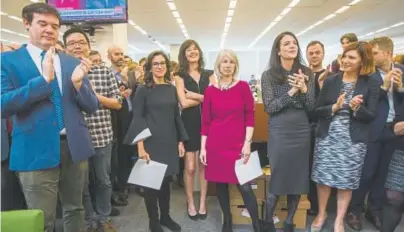  ??  ?? Beginning third from left, New York Times staff writers Jodi Kantor and Megan Twohey, senior enterprise editor Rebecca Corbett and reporter Cara Buckley celebrate with colleagues in the newsroom in New York after the team they led won the 2018 Pulitzer...