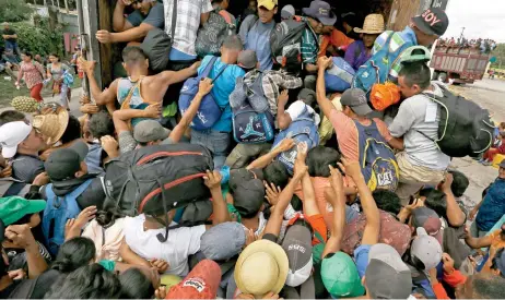  ??  ?? Ante la falta del transporte prometido por el gobierno de Veracruz para su traslado a la Ciudad de México, migrantes se aglutinan para aprovechar un aventón.