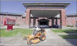  ?? MIKE BROWN/THE COMMERCIAL APPEAL ?? Although Carver High School in South Memphis was closed by Shelby County Schools last week, a lawn maintenanc­e crew was busy there keeping the grounds up Monday morning.