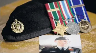  ?? PHOTOS: ADRIAN WYLD/The Canadian Press ?? A photo of Cpl. Stuart Langridge is seen on a table along with his beret and medals during a news conference on Parliament Hill in Ottawa in late 2010. Langridge’s family spent years trying to uncover the circumstan­ces of the soldier’s death.