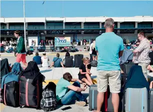  ?? AFP ?? Tourists wait outside the terminal building at the airport on Kos following the earthquake. —