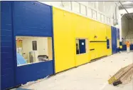  ?? Westside Eagle Observer/MIKE ECKELS ?? The west wall of the basketball/volleyball court at Decatur High School’s Peterson Gym shows the new paint scheme along the three main walls, which are painted in the school’s blue and yellow colors, this time from the floor to the bottom of the windows. The gym restoratio­n is expected to be completed by mid-August.