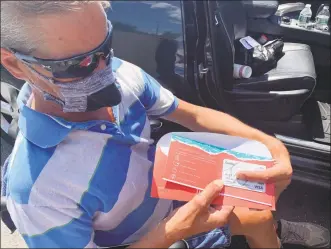  ?? Michael P. Mayko / Hearst Connecticu­t Media ?? Jay Lynk, a former AAA driver who was nearly killed in 2017 while helping a disabled vehicle, displays the gift cards he frequently hands out to needy people.