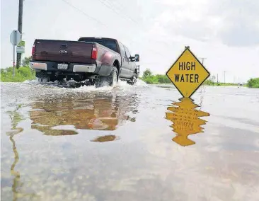  ?? [AP PHOTO] ?? A truck passes down a road with rising water Friday in Sargent, Texas.