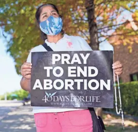  ?? LM OTERO/AP ?? Maria Peña holds a rosary and sign out outside a building housing an abortion provider in Dallas on Thursday.