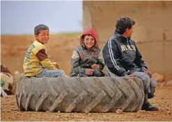 ??  ?? KHARUFIYAH: Displaced Syrian children, who fled their hometowns due to clashes between regime forces and the Islamic State (IS) group, sit on a wheel outside a tent in Kharufiyah, 18 kilometers south of Manbij. — AFP