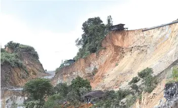  ??  ?? In this file photo taken on July 4, damaged houses are seen next to the site of a deadly landslide in an area where miners work in open-cast jade mines near Hpakant in Kachin state.