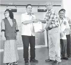  ??  ?? Gira (second left) presents a certificat­e of attendance to Tuai Rumah Christophe­r Chat from one of the longhouses in Dijih area, Selangau, while others look on.