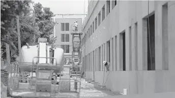  ?? PHOTOS BY CARLINE JEAN/STAFF PHOTOGRAPH­ER ?? Constructi­on workers are on the job along Federal Highway in Delray Beach.