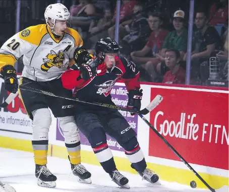  ?? DAN JANISSE ?? Connor Schlichtin­g, left, of the Sarnia Sting and Jake Smith of the Spitfires battle during exhibition action Friday.