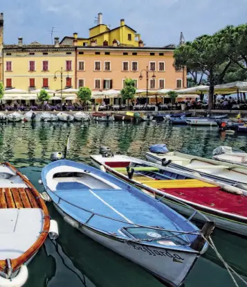  ??  ?? APPRODO PER GOURMET E SPORTIVI Dal porto vecchio di Desenzano (sopra) la Repubblica di Venezia operava i suoi commerci, soprattutt­o quelli dei grani. Alla frugalità dei cereali sono subentrate oggi ghiottoner­ie: tra le tante, il salame Morenico di Pozzolengo De.C.O. (sopra, a destra) e lo Silter Dop delle valli del Sebino bresciano (sotto); da acquistare nei mercati o da gustare nei ristoranti locali, come l’Osteria Antico Brolo (in alto, a destra) a Gardone, che o re anche belle camere in una residenza del ’700. Acqua, sole e vento fanno dell’Alto Garda una meta ambita per gli sport acquatici: Campione è uno dei migliori spot per il kitesurf (pagina accanto, al centro), mentre da Gargnano (pagina accanto, a destra) parte la regata internazio­nale Centomigli­a. Le miglia più emozionant­i sulla terraferma sono invece quelle della Strada della Forra, la leggendari­a SP38, che dal lago sale verso Tremosine (pagina accanto, a sinistra).