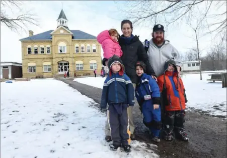  ?? MATHEW MCCARTHY, RECORD STAFF ?? Heather Seiling holds her daughter Edwina Wood, 2, behind her sons Ripley Wood, 3, and Wellington Wood, 5, and next to Kevin Gautier and his son Liam, 6, at Ayr Public School on Monday. Some parents there want French immersion in their community.