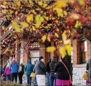  ?? ASSOCIATED PRESS FILE PHOTO ?? Voters stand in line outside of Pere Marquette Depot to cast their ballots in Bay City on Election Day.