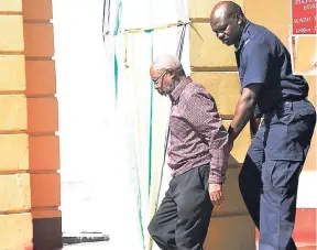  ?? COURTNEY LOCKE PHOTO ?? Moravian minister Rupert Clarke being escorted from the courthouse by police personnel recently. The scandal swirling around Clarke, who has been charged with sexual indiscreti­ons with a minor, has triggered debate across Jamaica about the church and...