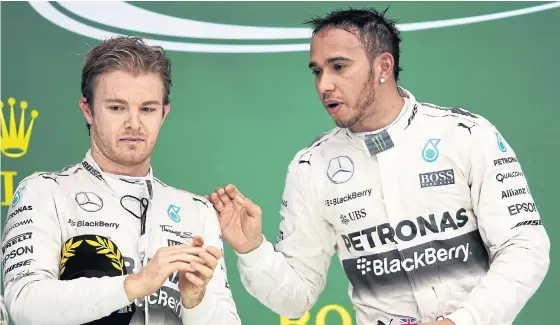  ??  ?? Lewis Hamilton, right, and Mercedes teammate Rosberg celebrate on the podium at the United States Grand Prix.