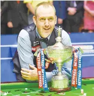  ?? — AFP photo ?? Wales’ Mark Williams poses with the trophy after beating Scotland’s John Higgins in the World Championsh­ip Snooker final match at The Crucible in Sheffield, England.