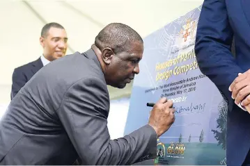  ?? FILE ?? Urban Developmen­t Corporatio­n Chairman Senator Ransford Braham endorses the unveiled Houses of Parliament Design Competitio­n poster at the official launch in May. Prime Minister Andrew Holness looks on.