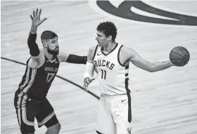  ?? BENNY SIEU/USA TODAY SPORTS ?? Bucks center Brook Lopez (11) looks to pass the ball away from Grizzlies center Jonas Valanciuna­s in their April 17 game.