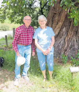  ??  ?? Dan Brizzle (Keep New Zealand Beautiful) and Joan Leckie (Forest & Bird) stand in the shade of the 100-year-old Northern rata at the Kimberley Reserve on the shores of the O¯ hau River, which is edging closer to the notable tree every winter.