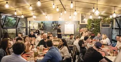  ?? ?? HAPPY HOUR. Diners at the new Pizzeria LÕElementa­re, which serves up thin-crust pizzas and craft beers, in Rome.